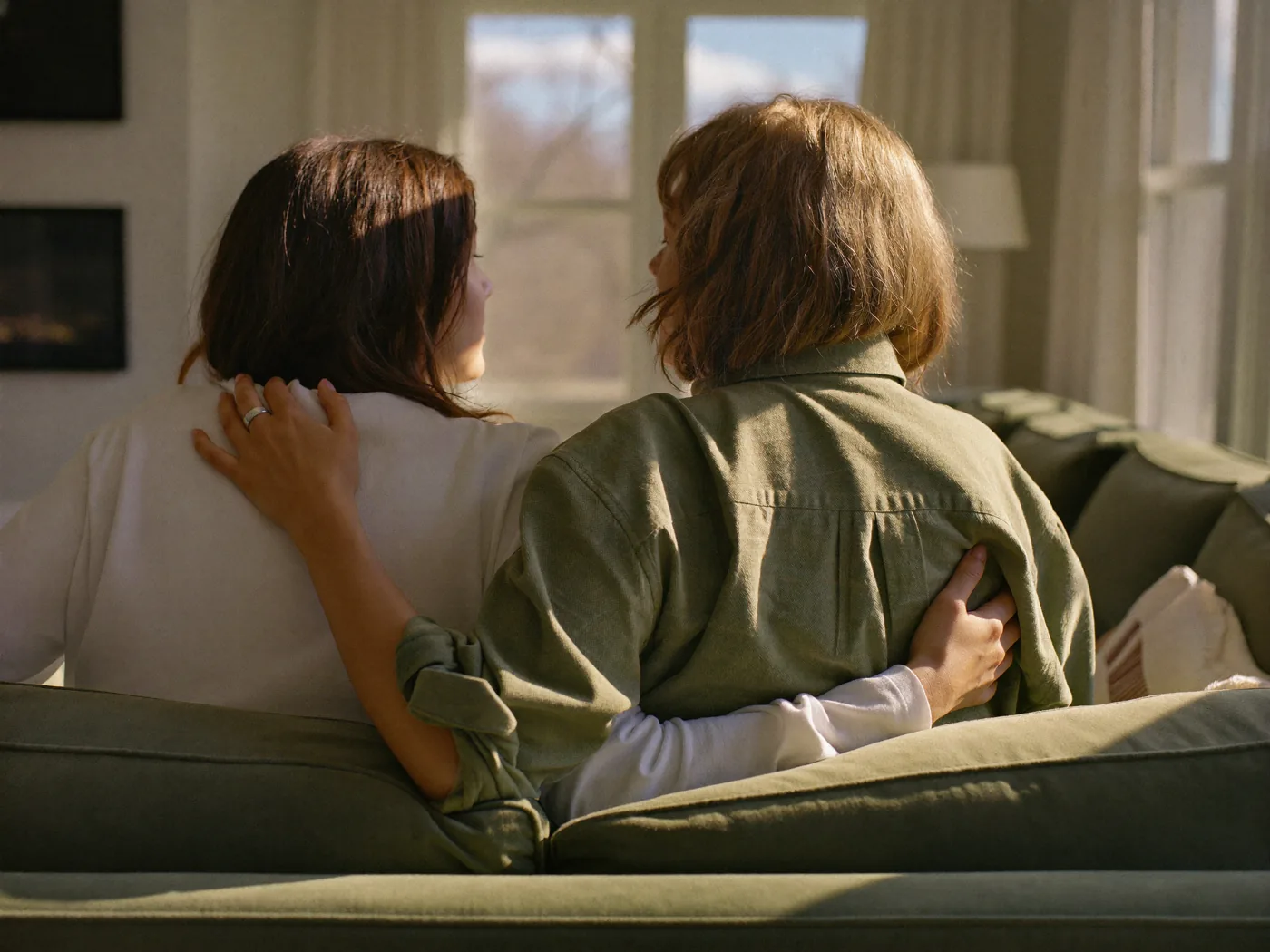 One woman gently comforting another in warm light